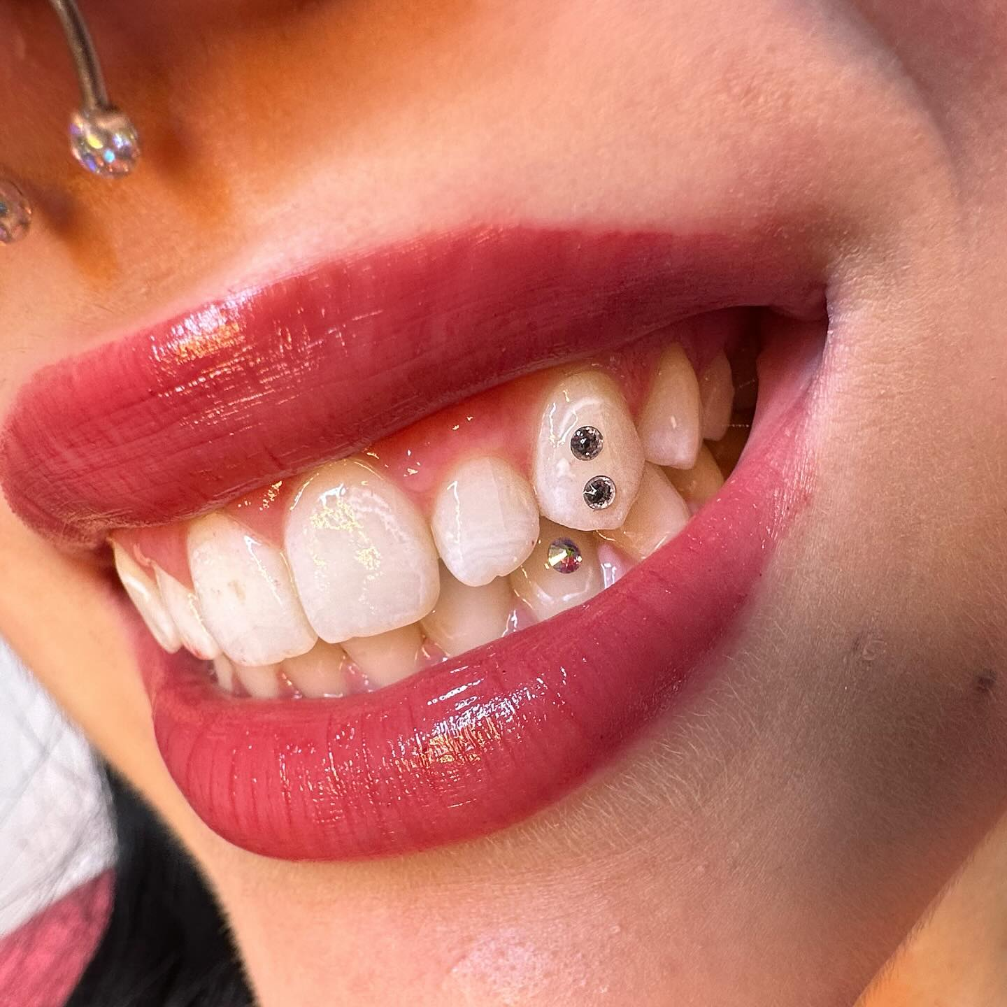Tooth gem close-up on glossy lip